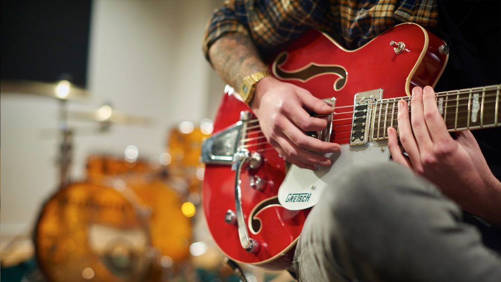 student playing a guitar