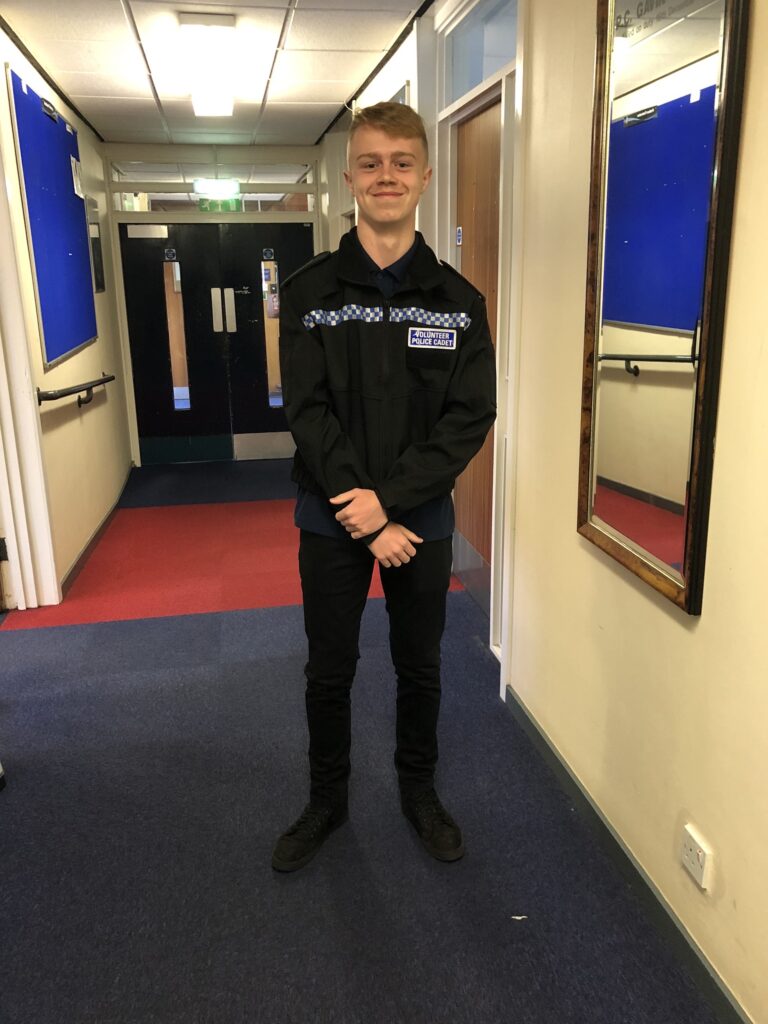 Kien Kirk smiles at the camera dressed in his police cadet uniform