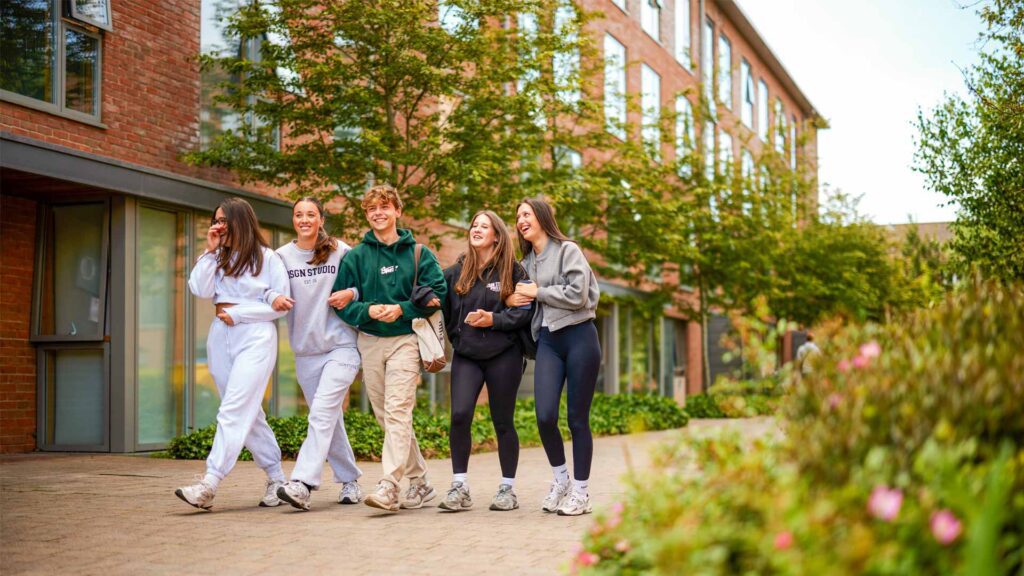 Students laughing together while walking around our green campus