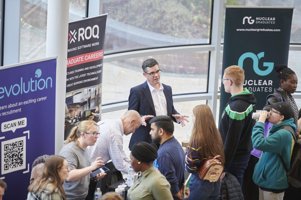 Students at a Careers fair discussing with different representing employers.