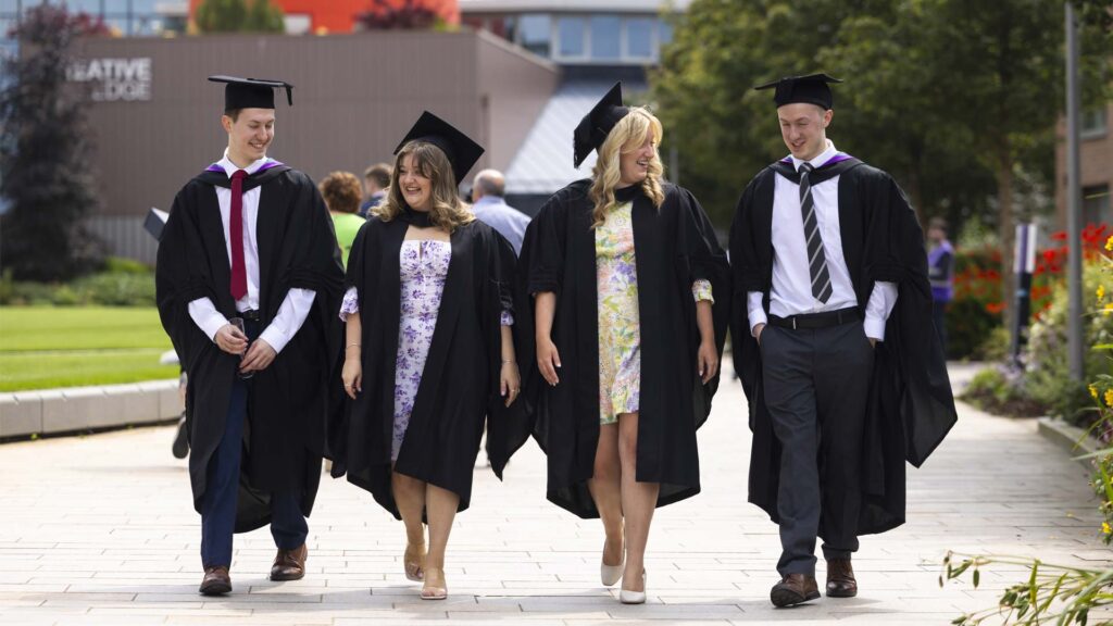 Graduates walking in front of Creative Edge 