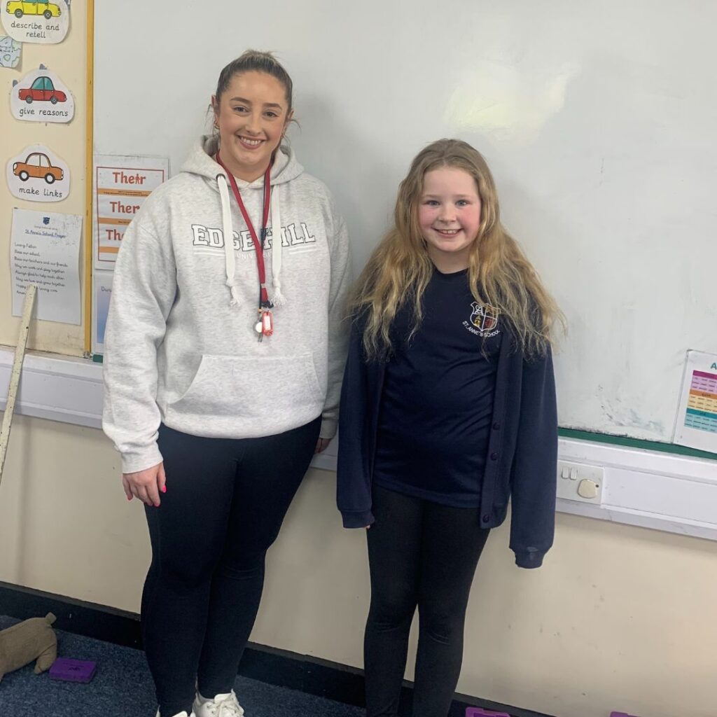student Erin McKenna stood next to school pupil in classroom setting